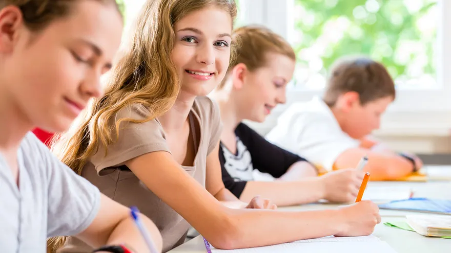 Skupina mladých ľudí sediacich pri stole