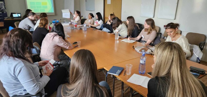 Na fotografii účastníci z Banskobystrického kraja sediaci na stoličkách okolo stola diskutujúci s prednášajúcou