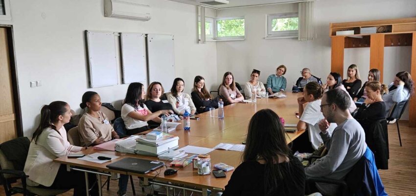 Na fotografii účastníci z Banskobystrického kraja sediaci na stoličkách okolo stola diskutujúci s prednášajúcou