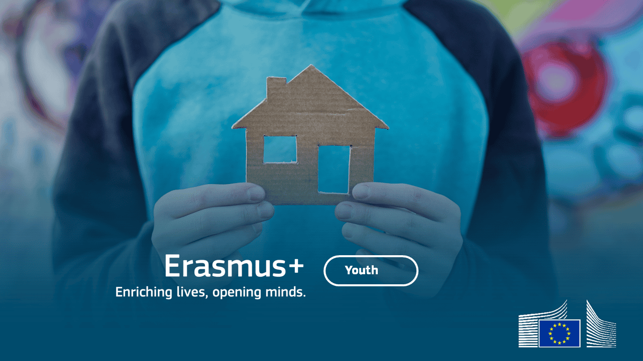 Mladý človek drží maketu domu z kartónového papiera