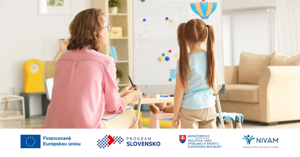 Učiteľka sedí pri žiačke a vysvetľuje jej na tabuli.