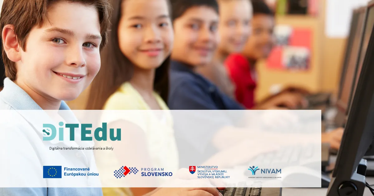 Žiaci sediaci pri počítačoch hľadia do objektívu.