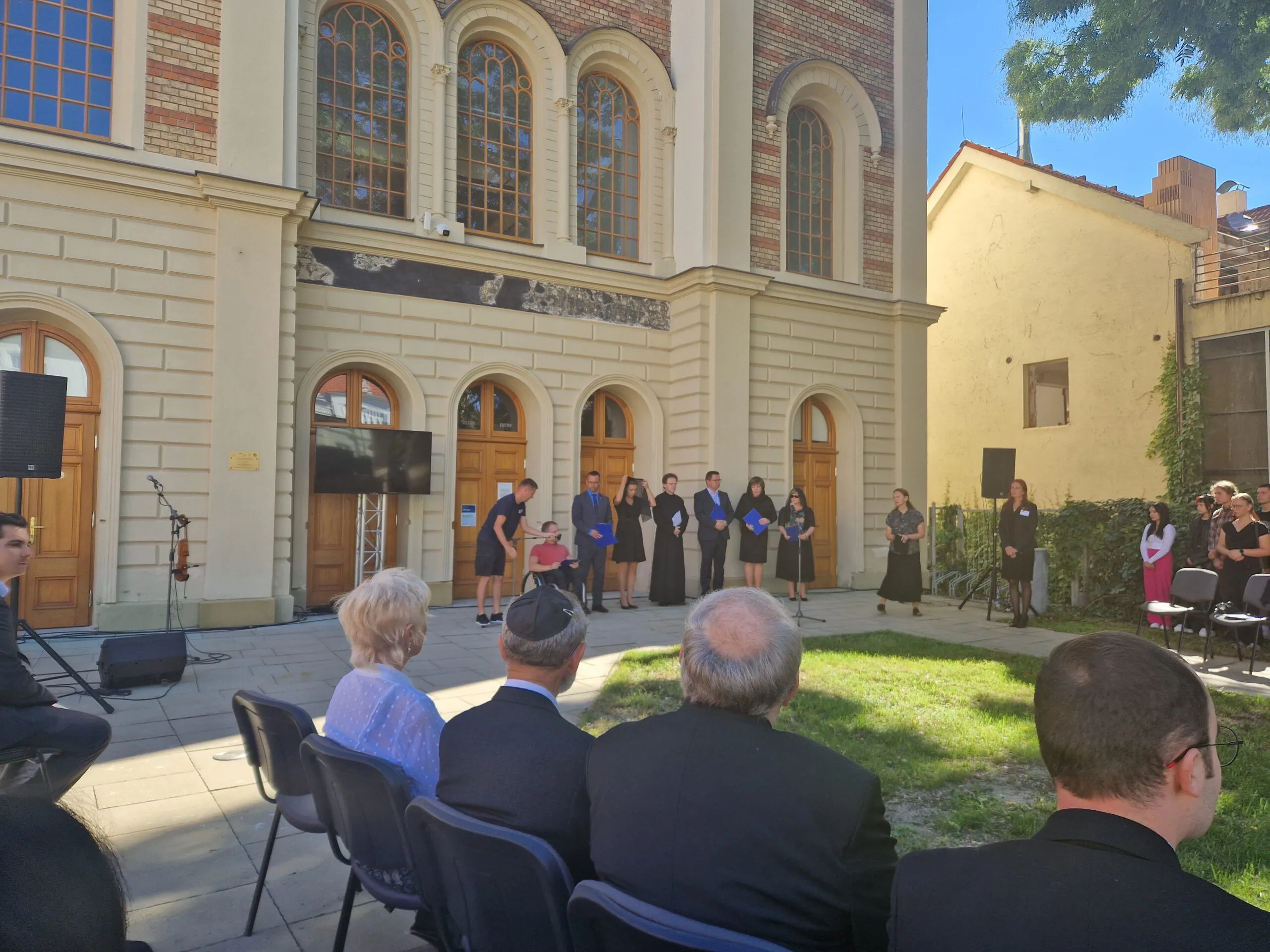 Na fotke skupina účastníkov pietnej spomienky pred budovou.