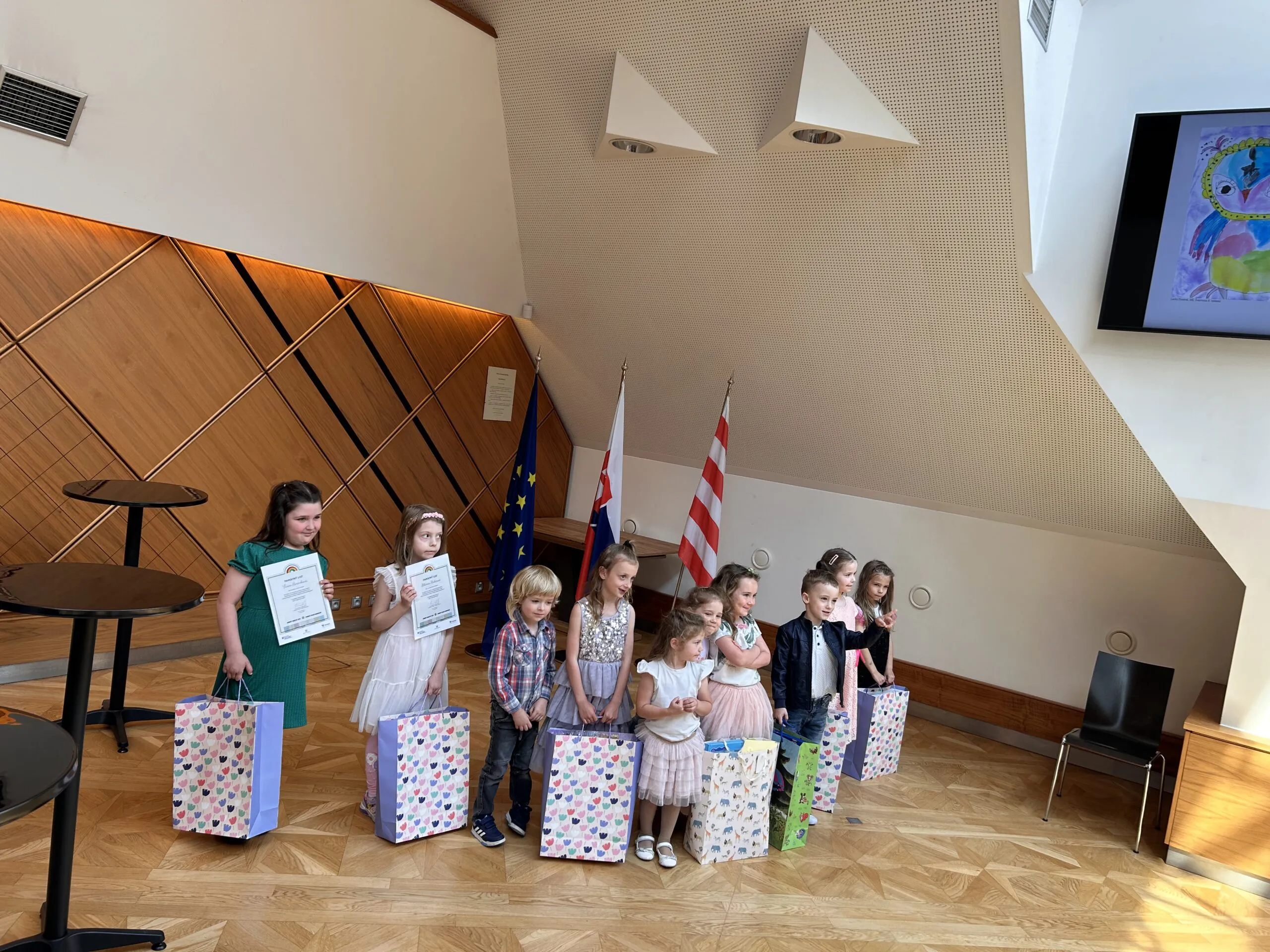 Na obrázku sú malé deti z materskej školy, ktoré v rukách držia diplomy a balíčky ako odmenu za sútaž.