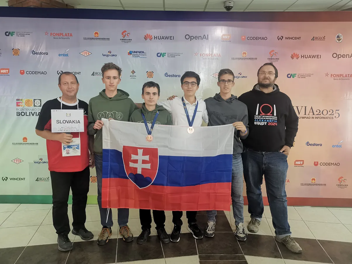 Na obrázku sa nachádza šesť chlapcov, ktorí držia vlajku Slovenska a pozerajú sa do objektívu kamery.