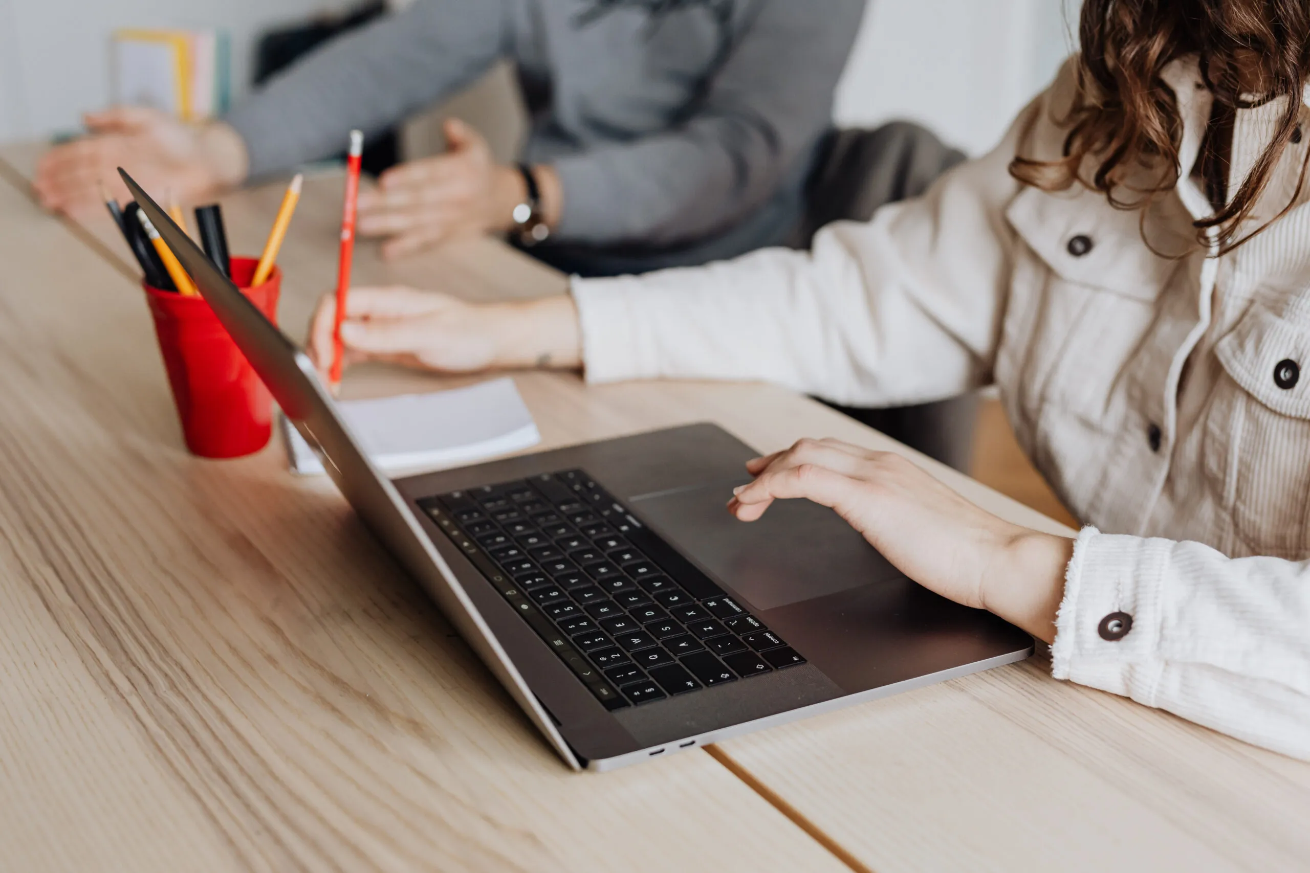 Na fotke zachytené ruky píšuce na notebooku.