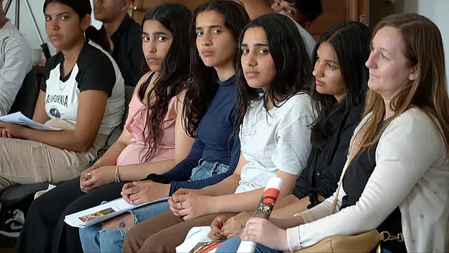 Šesť žien sedí v hľadisku a počúvajú prednášku.