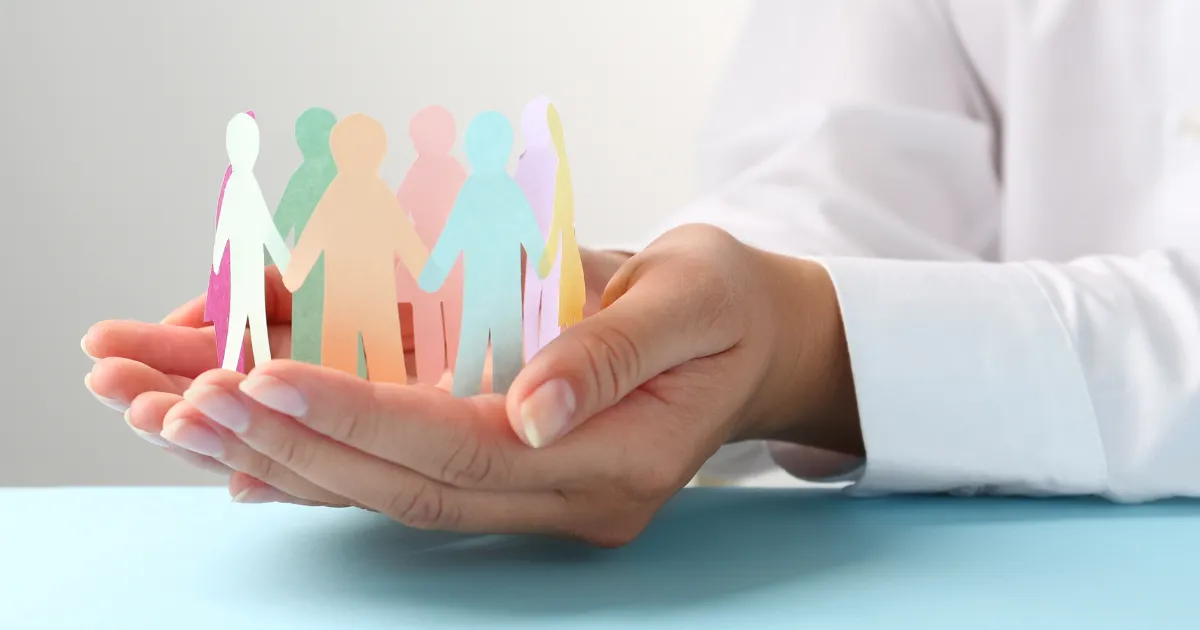 Ruky držia papierových ľudí.