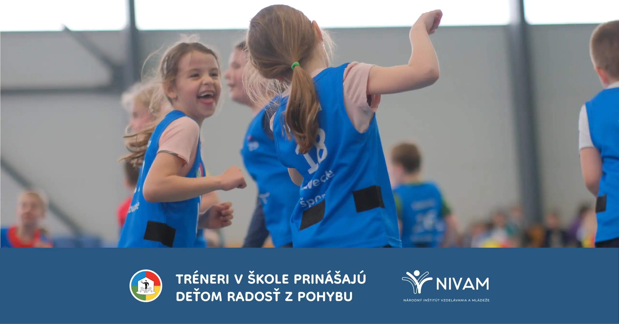 Deti v modrých tričkách v telocvični v pohybe.